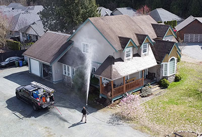 our employee washing a house with soft washing